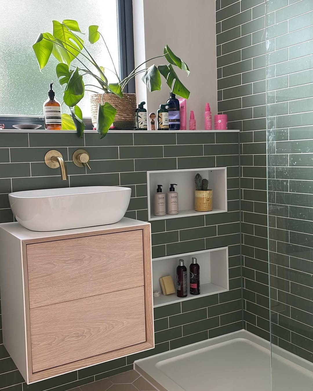 Bespoke green-tiled bathroom with brass fixtures installed by OAS Plumbing in Brighton