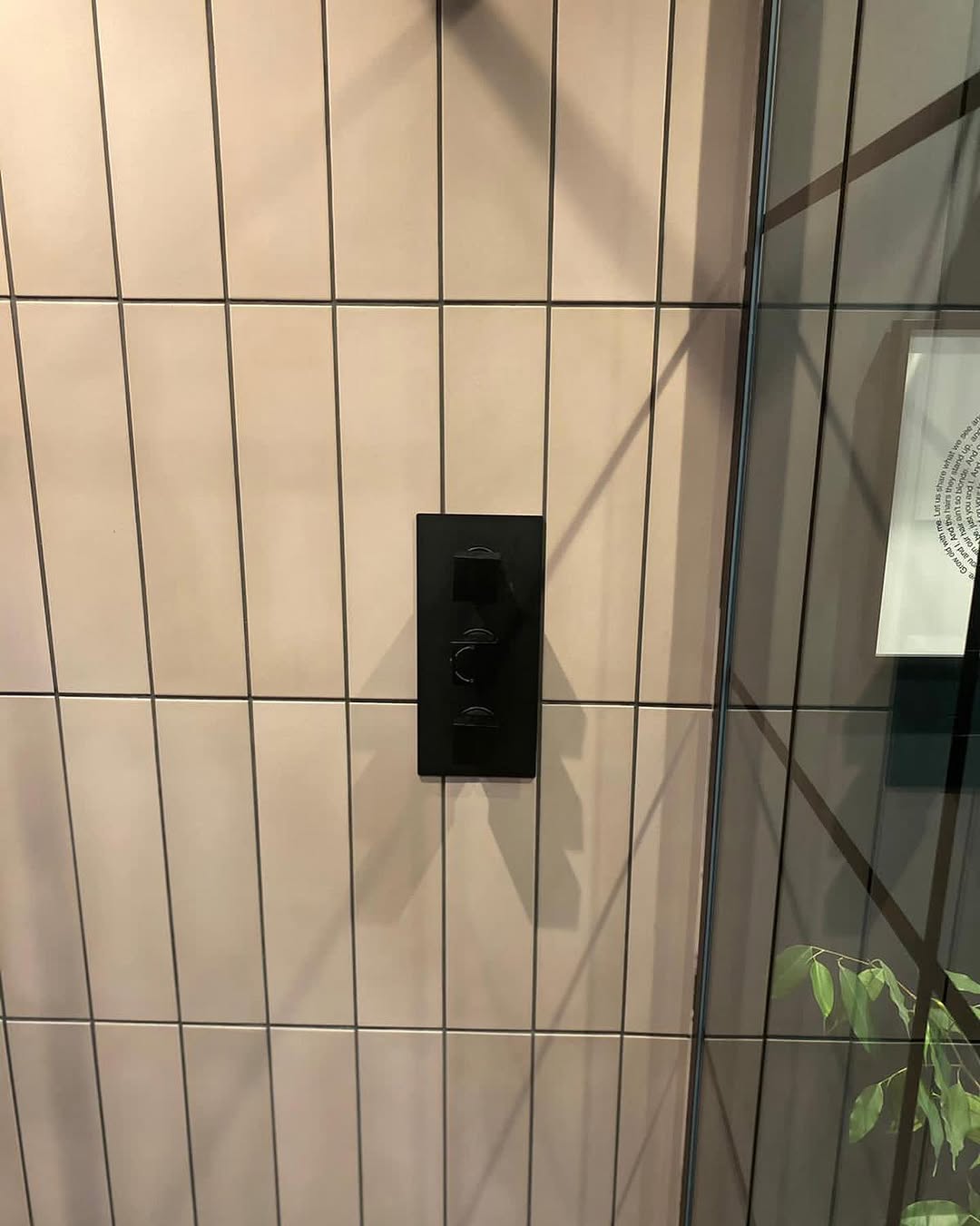 En suite detail showing black thermostatic shower valve against blush vertical tiles