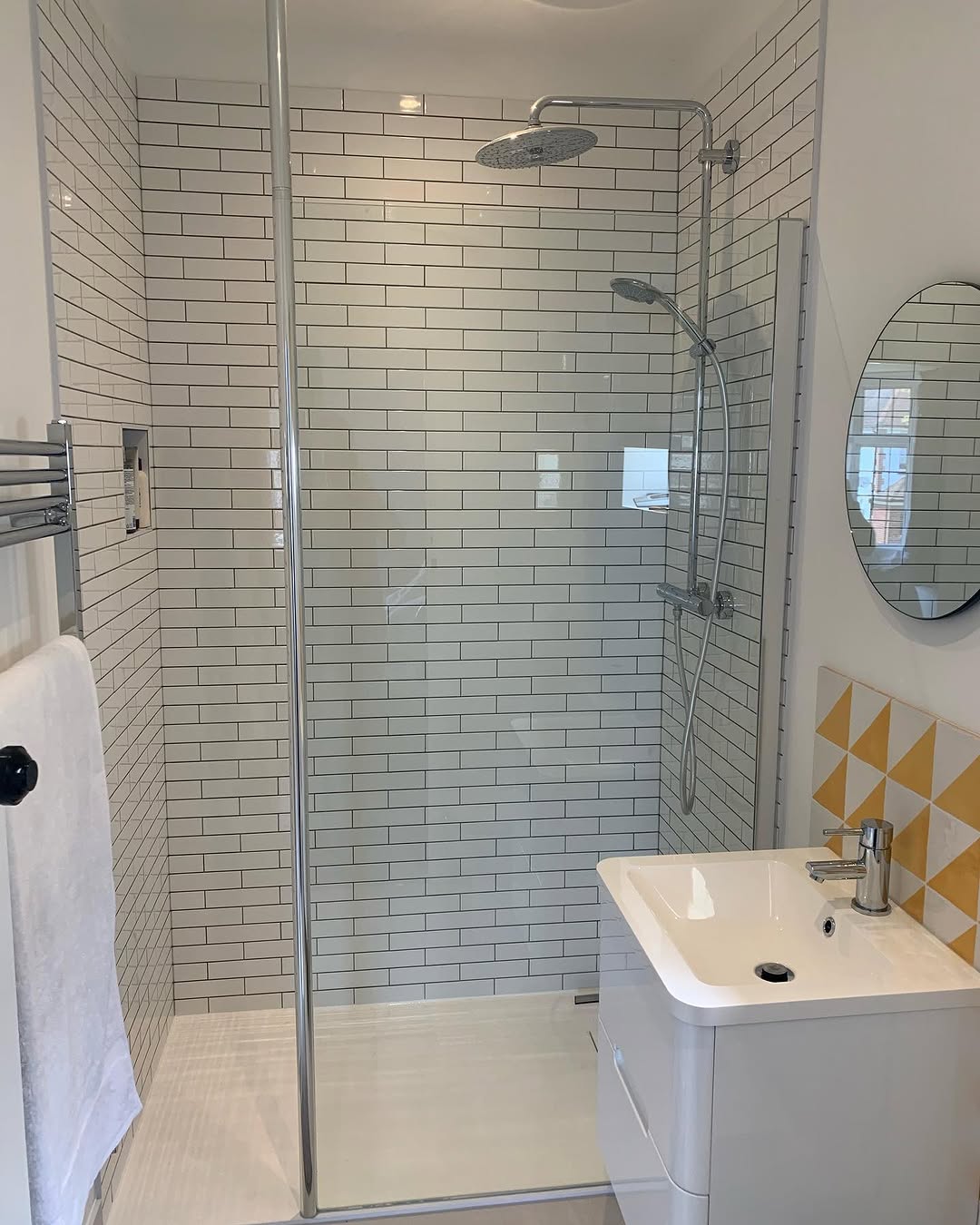 Family bathroom shower room with white subway tiles and chrome fittings